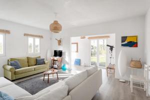 a living room with a couch and a table at Pinhal da Praia em Melides in Quinta da Cascalheirinha