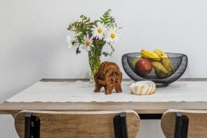 a table with a vase of flowers and fruit at Dimitra's House in Glossa