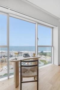 an empty room with a desk and large windows at Sal D’Ouro Skyline & Sea Views in Canidelo