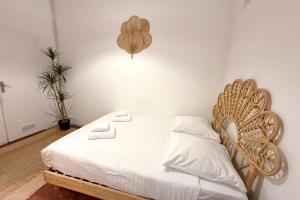 a bedroom with a white bed with a wooden headboard at Old Antibes 1 Bedroom 4 Persons in Antibes +1 photo