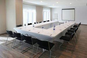 a large meeting room with a long white table and chairs at City Express Plus by Marriott Mexicali in Mexicali +48 photos