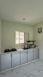 a kitchen with white cabinets and a sink and a window at Reef ALjabal Rest in Minthār