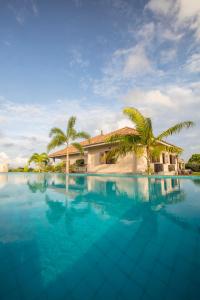 a swimming pool with a house and palm trees at Villa Mayurana by Edwards Collection in Koggala