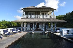 a house with a swimming pool in front of a building at Belle Mont Sanctuary Resort - Kittitian Hill in Ortons