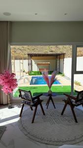 a ping pong table in a living room with a pool at Reef ALjabal Rest in Minthār