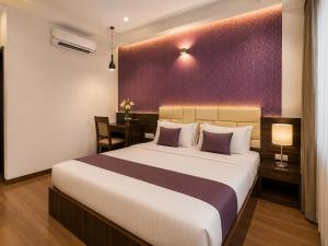 a bedroom with a large bed and a desk at Hotel Karma Inn Near Akshay Patra Jagatpura in Jaipur