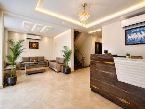 a lobby with a waiting room with couches and plants at Hotel Karma Inn Near Akshay Patra Jagatpura in Jaipur