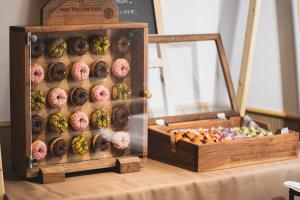a display of donuts in a display case on a table at Hotel NewNagano NeXT in Nagano