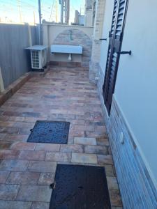 a patio with a bench and a brick wall at Le 2TORRI in Falconara Marittima