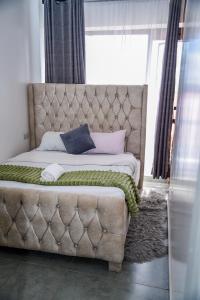 a bed with a tufted headboard in a bedroom at Royalty homes in Kiambu