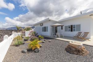 a white house with a garden in front of it at Glück House In Las Norias in Las Manchas