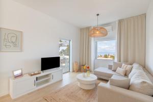 a living room with a white couch and a tv at Glück House In Las Norias in Las Manchas