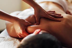 a woman laying on a bed with her hands on her back at The Pier Beach Inn & Suites in Willemstad