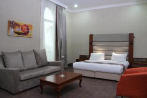 a hotel room with a bed and a couch at Batumi World Palace in Batumi
