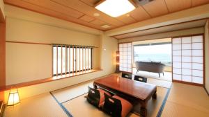 a room with a table in a room with a piano at Yururi Nishiizu in Ukusu