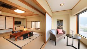 a living room with a couch chair and a table at Yururi Nishiizu in Ukusu