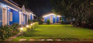 a yard with lights in front of a house at night at SUSAGADE in Vagator