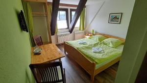 a small bedroom with a bed and a table at Ratskeller Geising in Geising