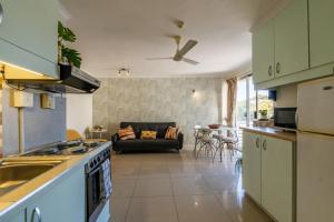 a kitchen and living room with a couch at 419 Ocean Breeze in Cape Town