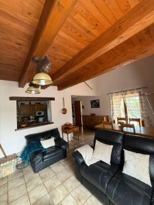 a living room with leather furniture and a wooden ceiling at Chez Polo Villa avec piscine et pool house privé in Vallon-Pont-dʼArc