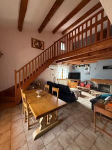 a living room with a wooden table and stairs at Chez Polo Villa avec piscine et pool house privé in Vallon-Pont-dʼArc