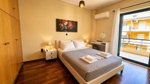 a bedroom with a bed with two towels on it at Seafront Luxury Apartment in Kalamata