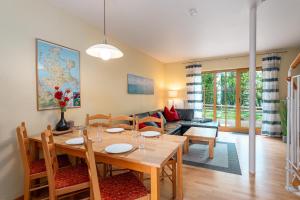 a dining room and living room with a table and chairs at Höfthus 8 - Bade- & Saunawelt täglich inklusive in Alt Reddevitz