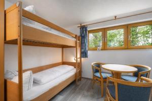 a small room with bunk beds and a table at Höfthus 8 - Bade- & Saunawelt täglich inklusive in Alt Reddevitz +50 photos