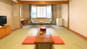 a living room with a table and a tv at 昆布川温泉幽泉閣 in Rankoshi +24 photos