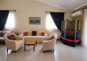 a living room with a couch and a table and chairs at Villa Alexandra Rio Patra in Áyios Vasílios