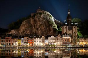 a city lit up at night in front of a mountain at Coquelicot in Waulsort