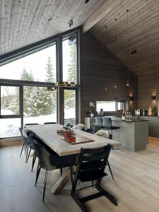 a kitchen and dining room with a table and chairs at Hafjell Luxury Lodge in Øyer