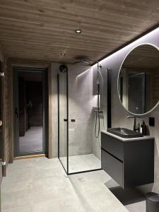 a bathroom with a shower and a sink and a mirror at Hafjell Luxury Lodge in Øyer +42 photos