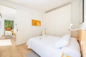 a bedroom with a white bed and a glass wall at Alfonsa in Pollença +28 photos