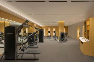 a gym with treadmills and machines in a room at Surat Marriott Hotel in Surat