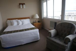 a hotel room with a bed and a chair at Marine Inn in Powell River