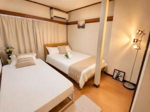 a small room with two beds in it at Yoshimi Stay Kawaguchi in Kawaguchi