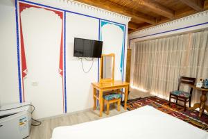 a bedroom with a bed and a tv on a wall at As-Salam Boutique Hotel in Bukhara