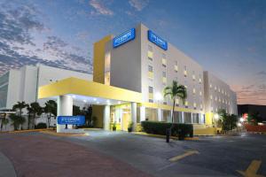 a large building with a sign in front of it at City Express by Marriott Cancun in Cancún