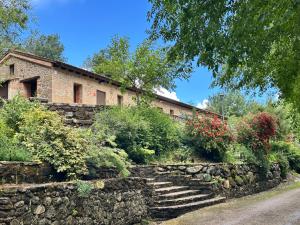 a stone wall and stairs in front of a building at Apartamentos El Escondite de Pedro Malillo in Candeleda