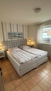 a large bed in a bedroom with two tables at Haus Katharina, Balkon mit Meerblick in Lauterbach