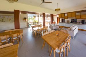 a dining room with tables and chairs and a kitchen at Saraswati Ubud in Ubud