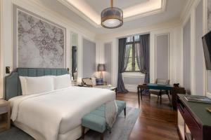 a bedroom with a large white bed and a desk at The ERAVATI Sule Grand Yangon in Yangon +51 photos