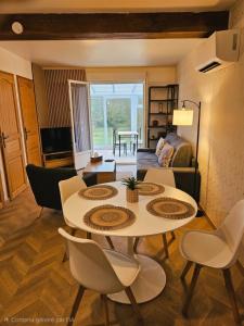 a living room with a table and chairs at Le passage, maisonnette cosy classée 4 étoiles in Pont-lʼÉvêque