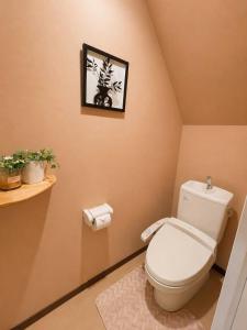 a bathroom with a toilet and a picture on the wall at Yoshimi Stay Kawaguchi in Kawaguchi