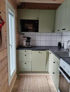 a kitchen with white cabinets and black counter tops at Villa Goškanjávri in Inari +10 photos