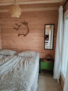a bedroom with a bed in a wooden wall at Villa Goškanjávri in Inari