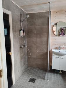 a bathroom with a shower and a sink at Villa Goškanjávri in Inari