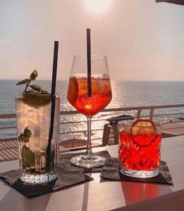 a table with a drink and two glasses on a balcony at Chioma verde in Chioma