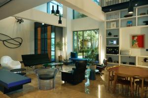 a living room with a piano and chairs and tables at La Casa Hotel Seoul in Seoul